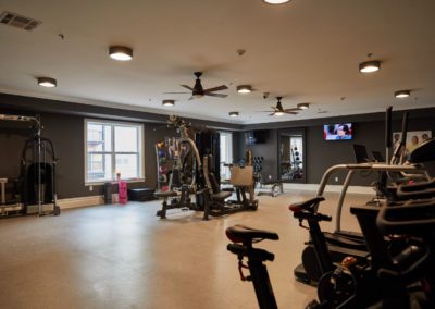 The fitness center at The Winston at Lyndhurst Apartments, equipped with cardio machines, strength training equipment, free weights, and resistance bands.
