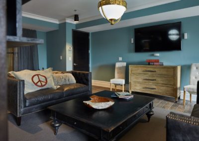 A living room at The Winston at Lyndhurst Apartments featuring a sofa with decorative pillows, a large coffee table, a mounted flat-screen TV, and stylish decor.