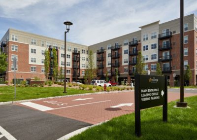 Exterior view of The Winston at Lyndhurst Apartments residential community, including an entrance area with visitor parking and a leasing office sign.