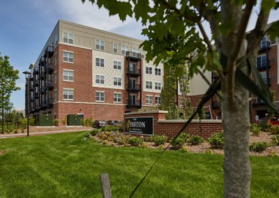 The exterior of The Winston at Lyndhurst Apartments building with private balconies and well maintained landscaping.